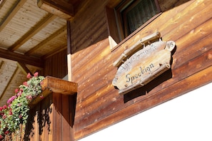 Un mur extérieur en bois sur lequel est apposée une enseigne indiquant « Appartenzen Speckkron ».