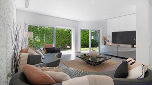 A modern living room with a sofa set, a coffee table, and a flat-screen TV. - Villa "Pine Lodge" gated residence with heated private pool (Vilamoura)