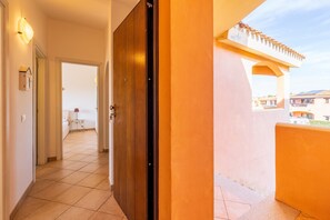 Un couloir menant à un balcon d’où l’on peut admirer les bâtiments.