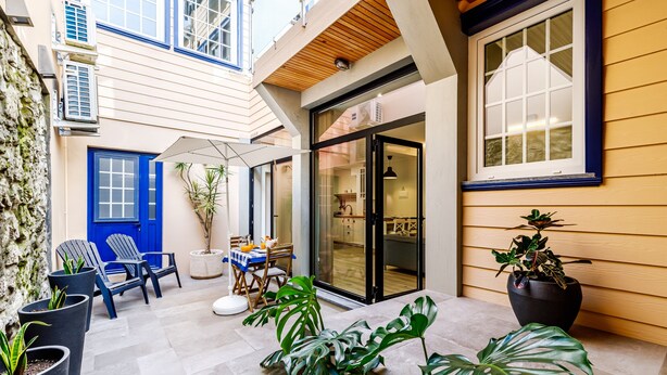 A modern building with a blue door, large windows, and potted plants. - Apartment 'Ladomar Avenida' with Private Terrace, Private Garden and Wi-Fi (Horta)