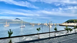 A marina with sailboats, a distant mountain, and a paved walkway with trees. - Apartment 'Ladomar Avenida' with Private Terrace, Private Garden and Wi-Fi (Horta)