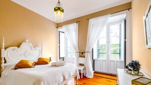 A bedroom with a bed, a nightstand, a chair, a dresser, and a window with curtains. - Apartment 'Ladomar Matriz' with Sea View, Private Terrace and Wi-Fi (Horta)