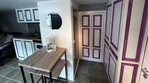 A compact kitchen with a coffee machine, a small table, and cabinets. - Charmant Studio, à 1km de la Baie D'authie (Groffliers)