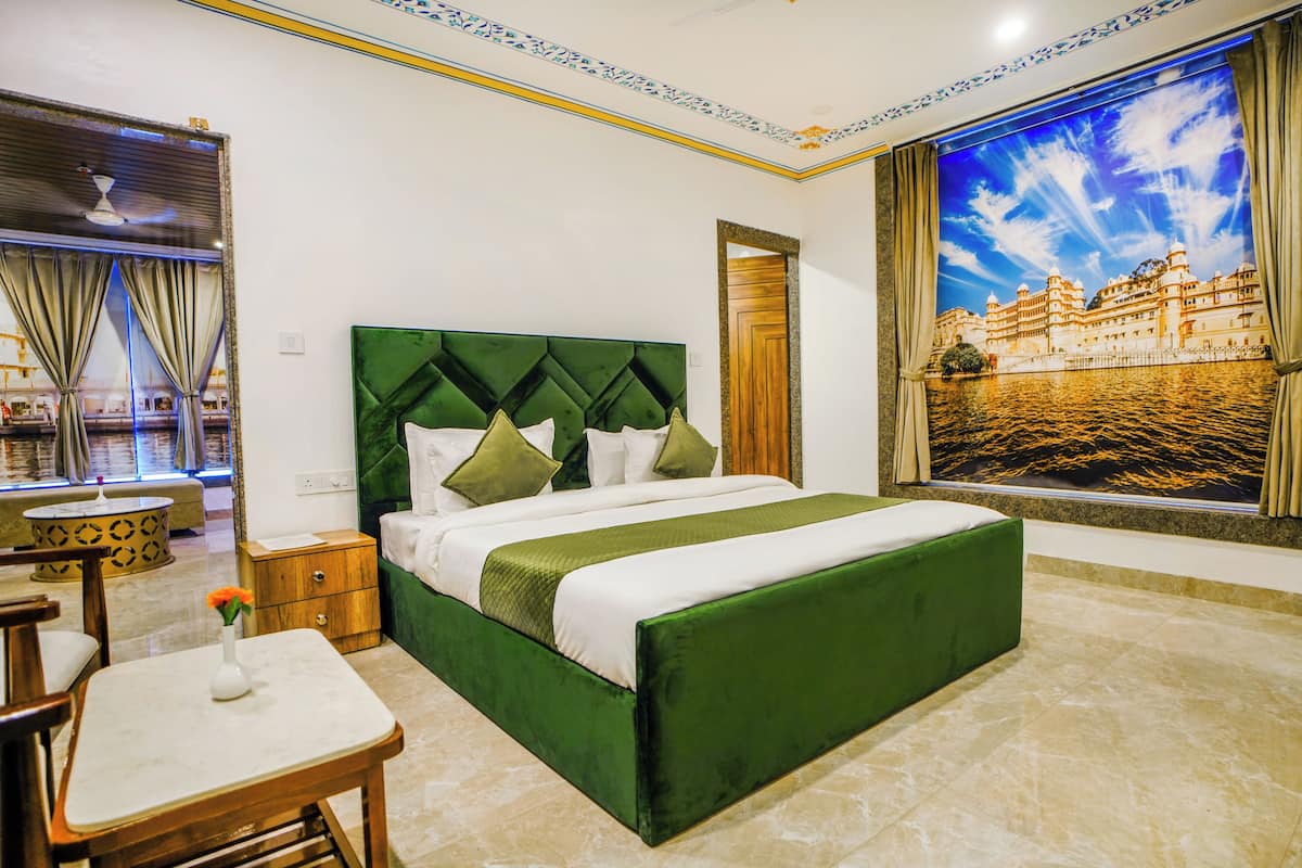 Habitación de hotel con una cama grande, una mesita con un jarrón y vistas a un palacio a través de un ventanal amplio.