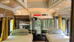 Interior de una autocaravana con dos camas, un pasillo central y un sistema de entretenimiento pequeño.