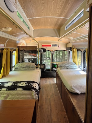 A campervan interior with two beds, a central aisle, and a small entertainment system. - Dog friendly trolley with Peanuts Theme (Middle Grove)
