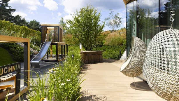An outdoor play area with a slide and a wooden structure labeled "UCHNIA". - Elite Apartments Brzeźno Premium (Gdansk)