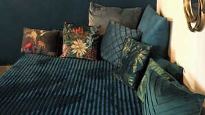 A bedroom with a dark blue wall, a bed with a striped bedspread, and three wall-mounted sunburst mirrors. - Sofia's canal-side mansion in San Stae luxury apartment with canal view (Venezia)