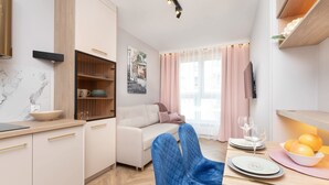Eine moderne Küche mit Holzschnitzereien, einer Marmorarbeitsplatte und einem Essbereich mit Tisch für zwei Personen.