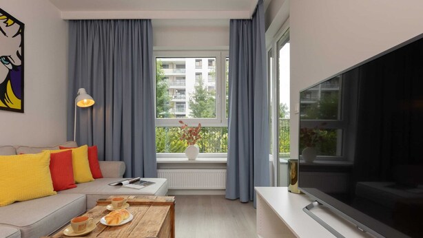 Een moderne woonkamer met een bank, salontafel en televisie.