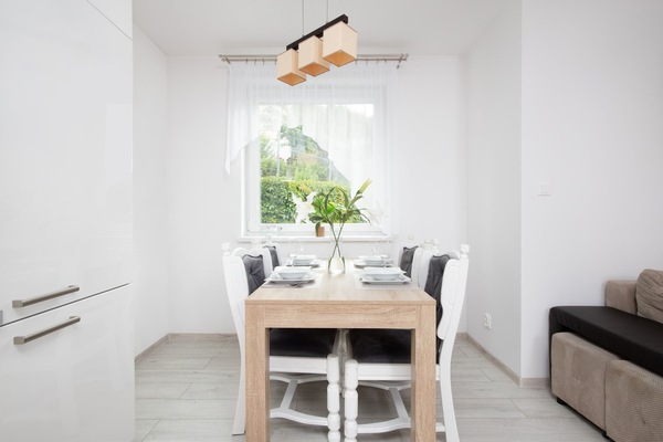 A dining area with a table set for four, complemented by natural light from the nearby window.