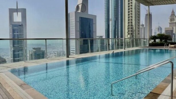 Une piscine à débordement située sur le toit, offrant une vue panoramique sur les gratte-ciel de la ville.