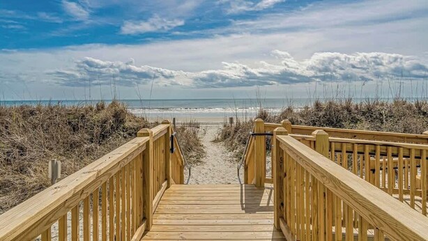 A wooden boardwalk leading to a beach with a clear sky. - Seafarer Unit 107 - Oceanview (North Myrtle Beach)