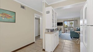 A compact living space with a kitchenette, a dining area, and a seating area with a view of the outdoors. - Seafarer Unit 107 - Oceanview (North Myrtle Beach)
