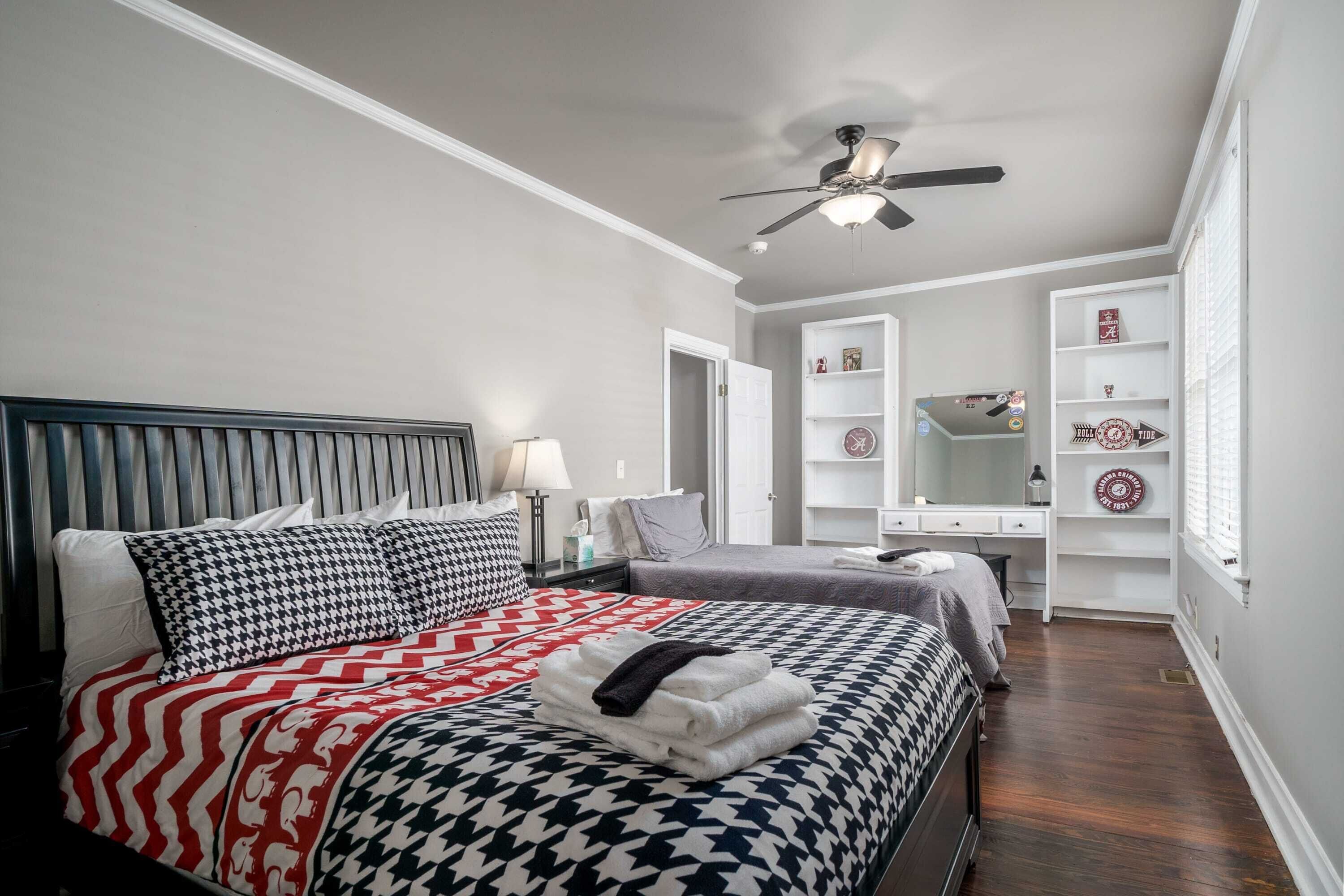 Une chambre à coucher comprenant un lit, des tables de chevet, un bureau et une armoire.