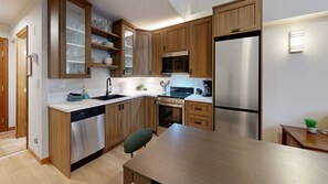 Efficient kitchen with stainless steel appliances and central island workspace.