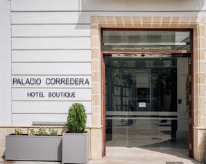 The entrance to Palacio Correndera Hotel Boutique with a modern glass door and a sign above it. - Hotel Boutique Palacio Corredera by Casas y Palacios (Jerez de la Frontera)