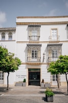 Un edificio blanco con balcones y un cartel que dice "Palacio Correndera Hotel Boutique".
