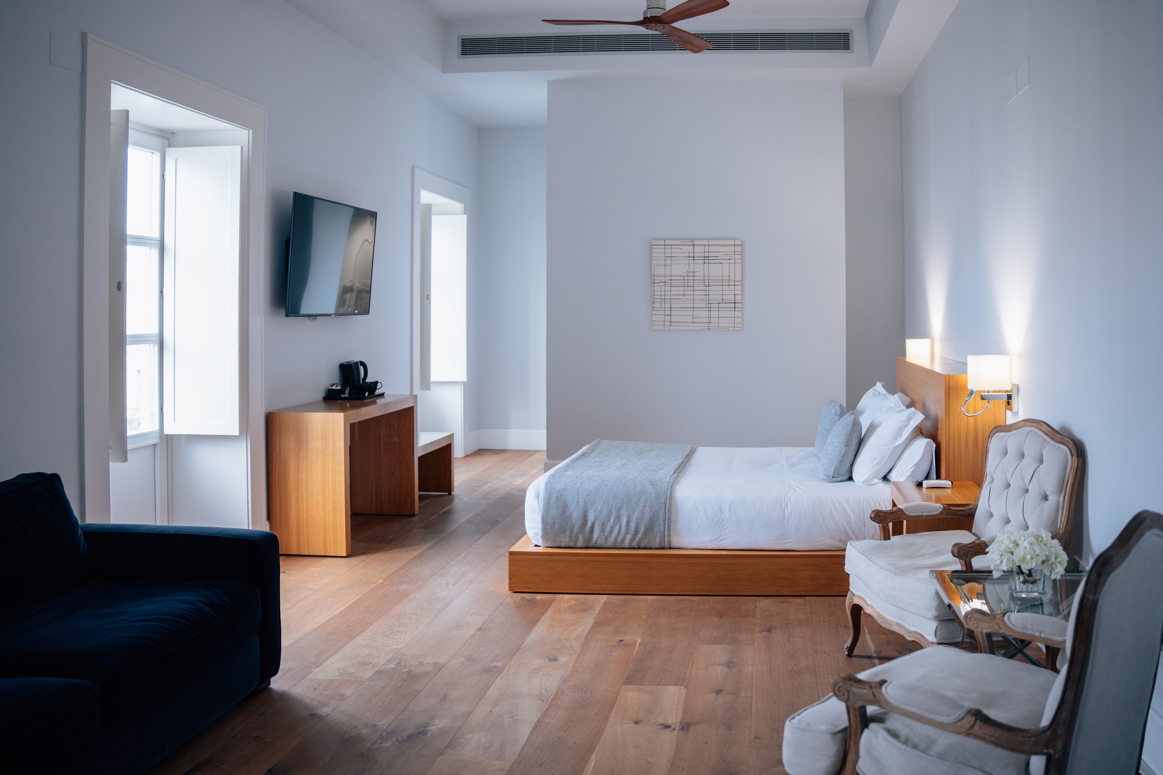 Une chambre moderne comprenant un lit, un bureau, une télévision et un coin salon.