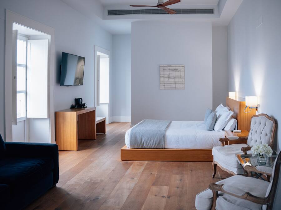 Une chambre moderne comprenant un lit, un bureau, une télévision et un coin salon.