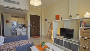 Un salon moderne avec un canapé, un téléviseur et un meuble de rangement pour les appareils multimédias.
