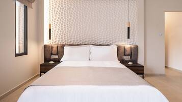 A modern hotel room with a large bed, two bedside tables, and a textured wall behind the bed.