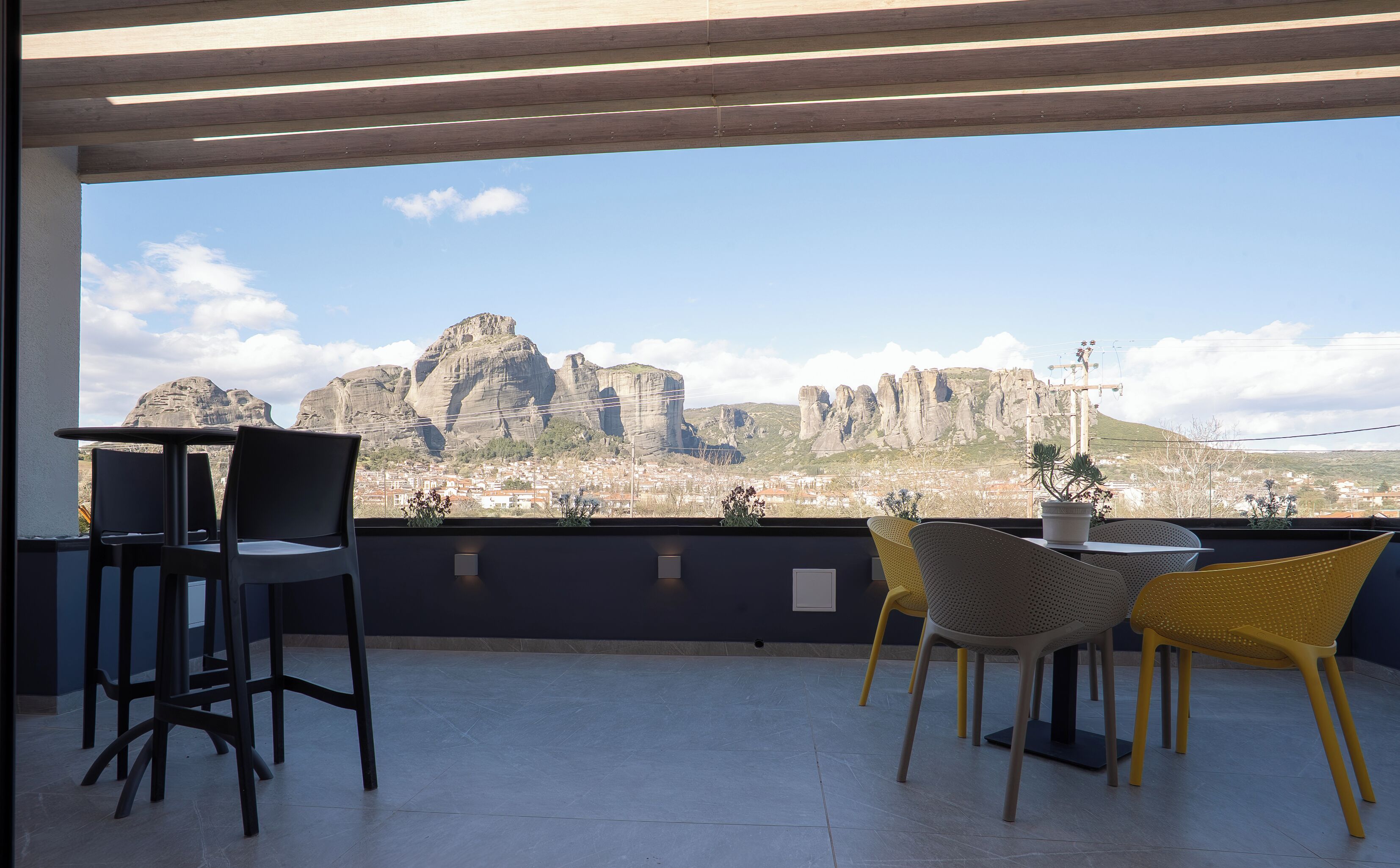 A terrace with a view of rock formations and a town in the background.