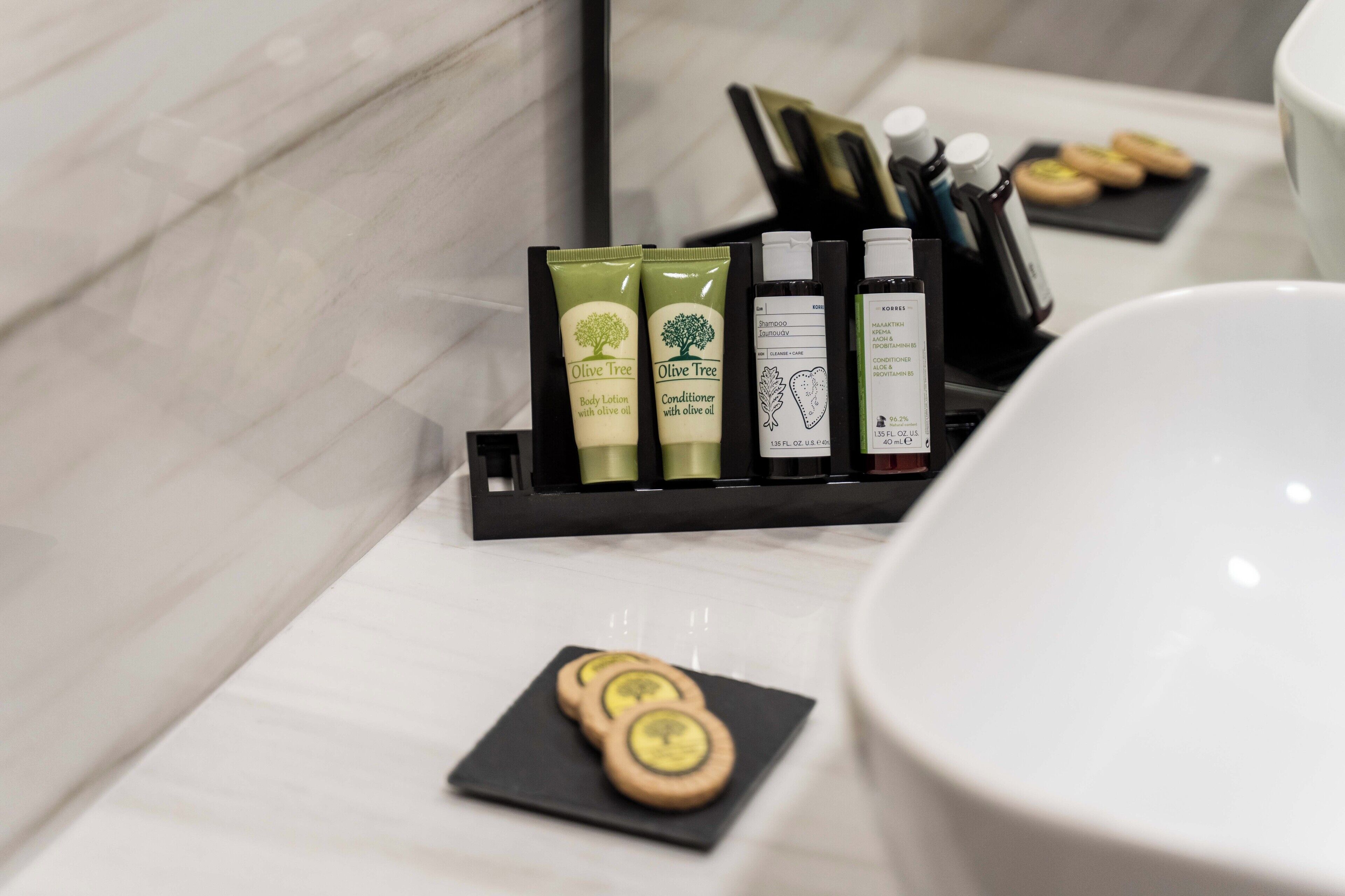 Una encimera de baño con artículos de aseo y un cuenco.