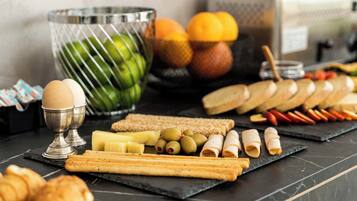 A variety of food items including bread, cheese, olives, and eggs on a black marble table.