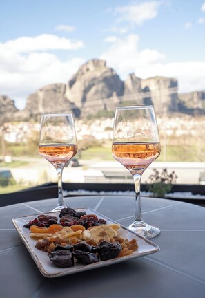 A table with two glasses of wine and a plate of assorted dried fruits. - Mirabilis Boutique Hotel  (Kalabaka)