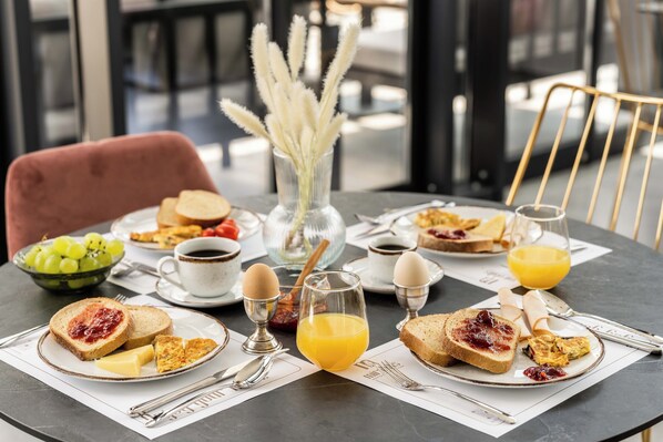 A breakfast table with toast, eggs, jam, and orange juice.