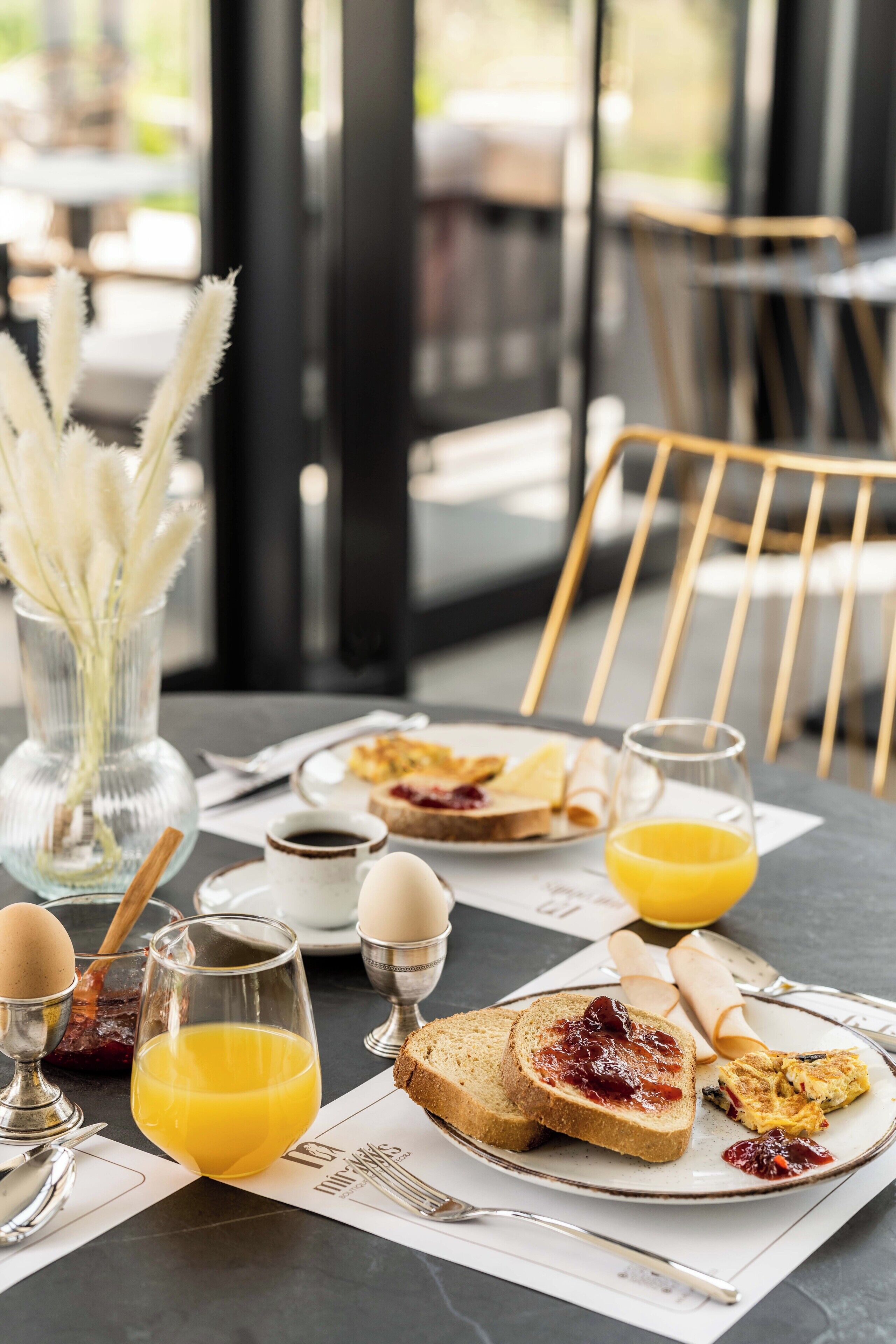 A breakfast setting with toast, eggs, and orange juice on a table.