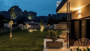 A modern outdoor patio with seating and a view of a mountain range.
