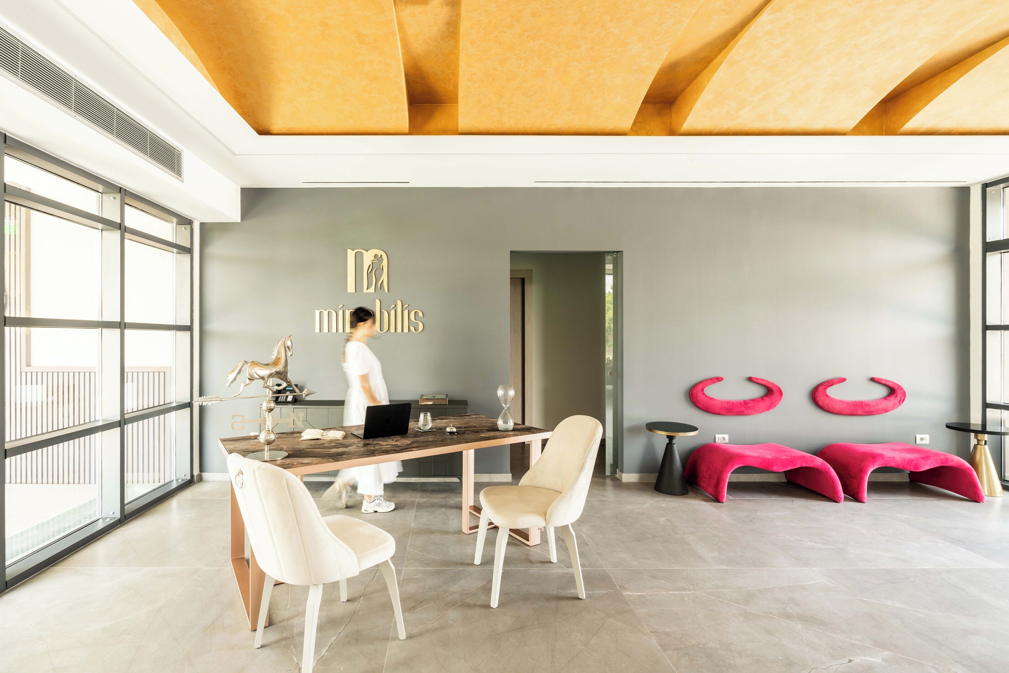 A modern interior with a large table, chairs, and a decorative horse sculpture.