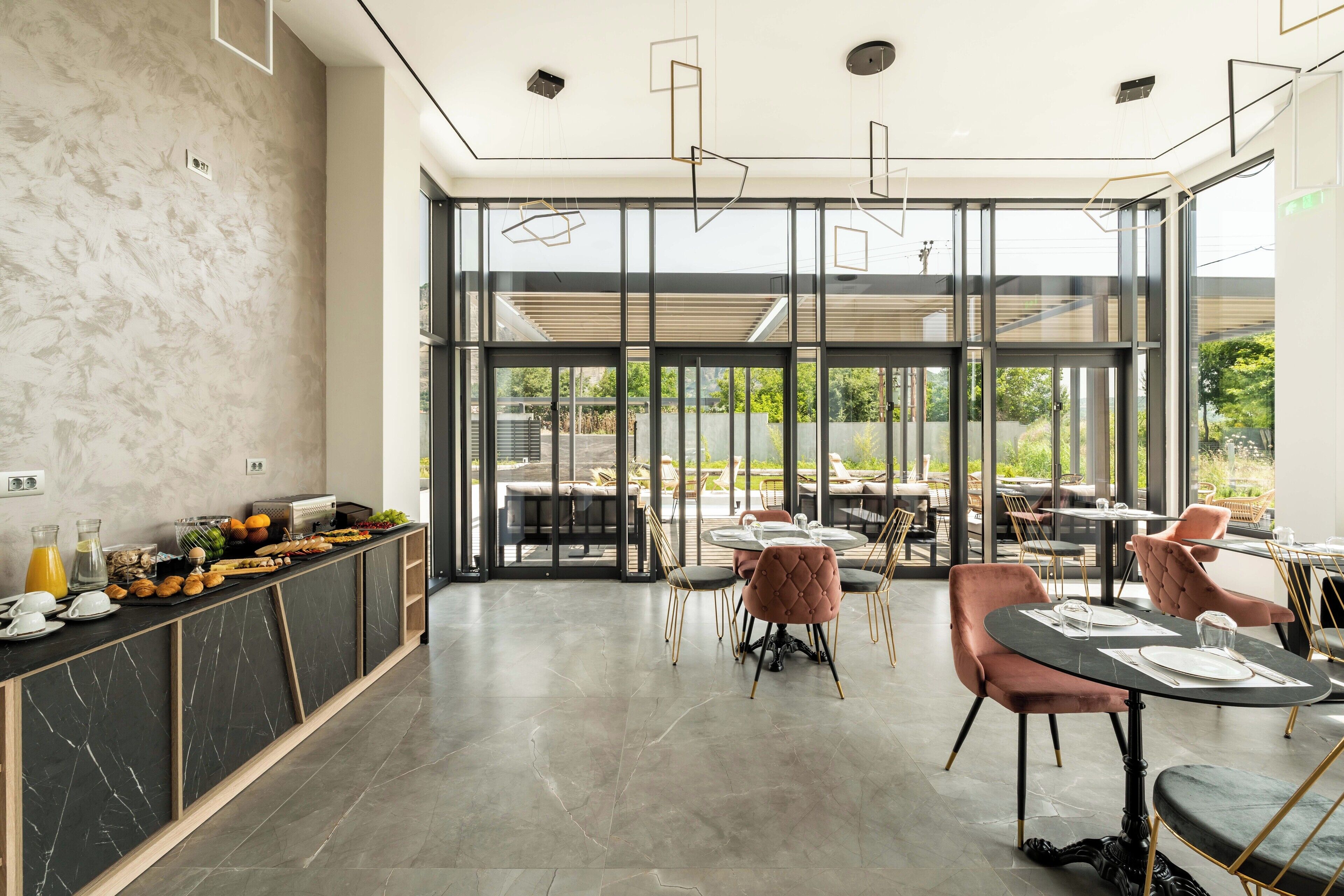 A modern dining area with a marble counter, glass doors leading outside, and comfortable seating.