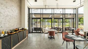 A modern dining area with a marble counter, glass doors leading outside, and comfortable seating.
