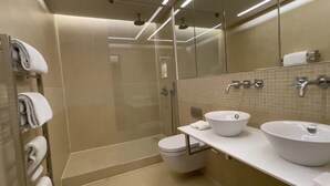 A modern bathroom with a glass-enclosed shower, a toilet, and two sinks. - Two Bedroom Flat in Belgravia (London)