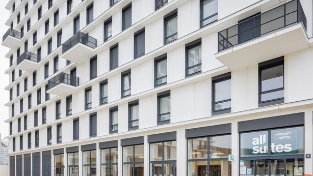 A modern hotel with multiple floors, large windows, and outdoor seating areas. - All Suites Appart Hôtel | Le Havre Centre - Les docks (Le Havre)