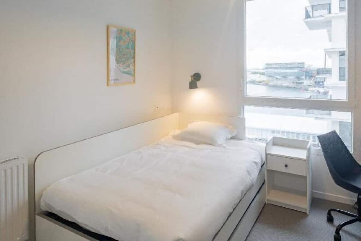 Premium bedding, desk, laptop workspace, blackout drapes