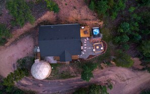An aerial view of a property with a large building, a swimming pool, and a spherical water tank. - Theater Dome | Stargazing Hot Tub Hammock Terrace (Bailey)