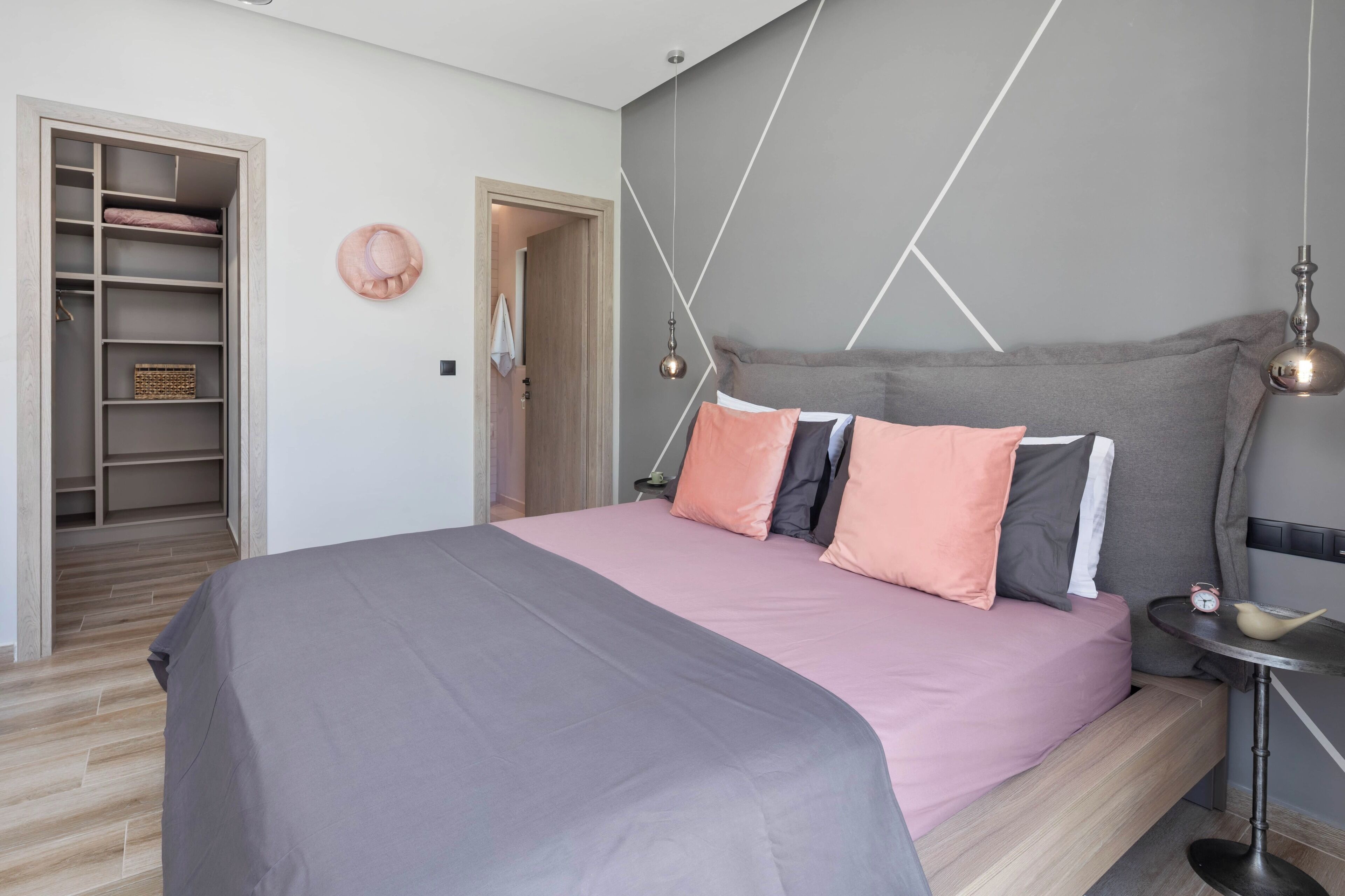 Une chambre à coucher moderne avec un lit, une table de chevet et une armoire.