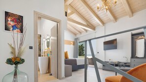 A modern interior with a bed, a TV, and a dining area. - Villa Tolena by Marilena Pagkrati (Corfu)