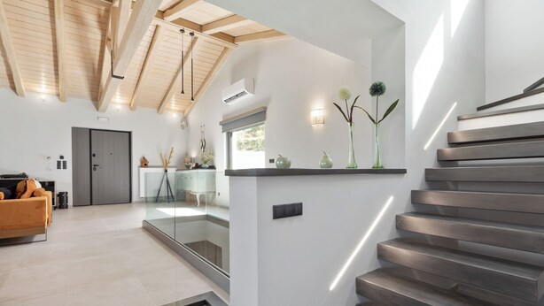 A modern interior with a staircase, a sofa, and a dining area. - Villa Tolena by Marilena Pagkrati (Corfu)