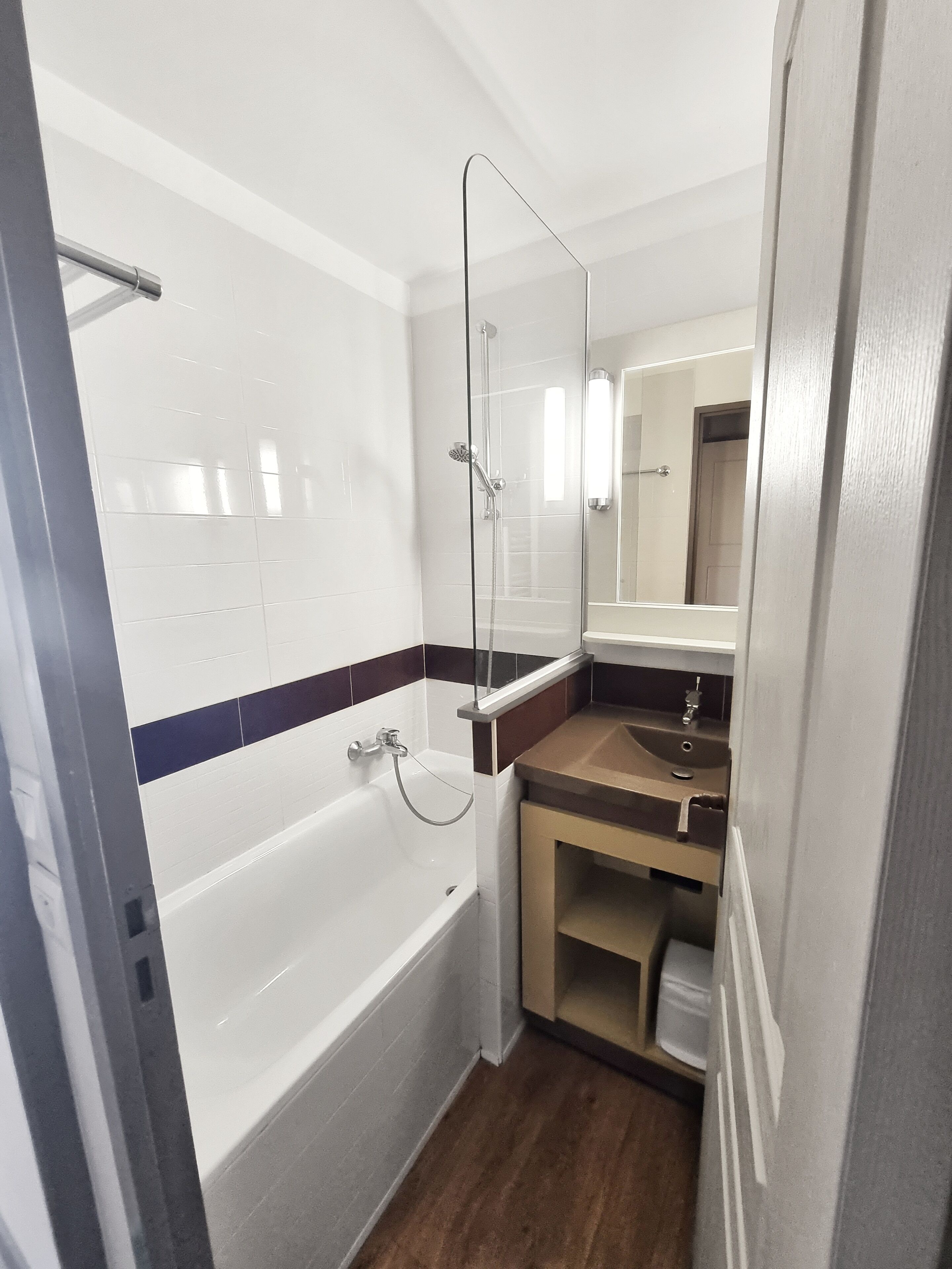 A compact bathroom with a bathtub, a shower, and a sink.