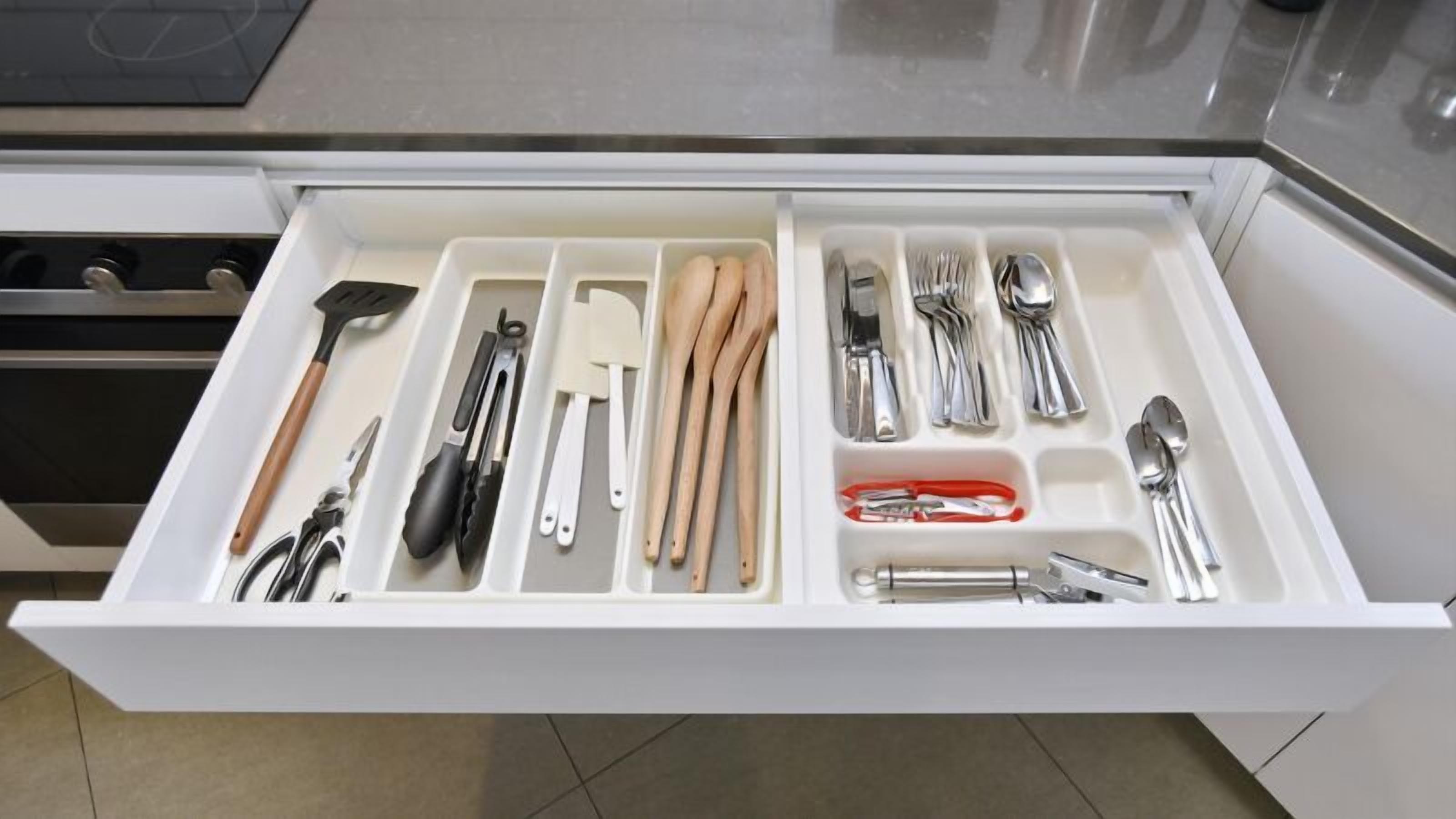 A kitchen drawer with utensils and cookware.