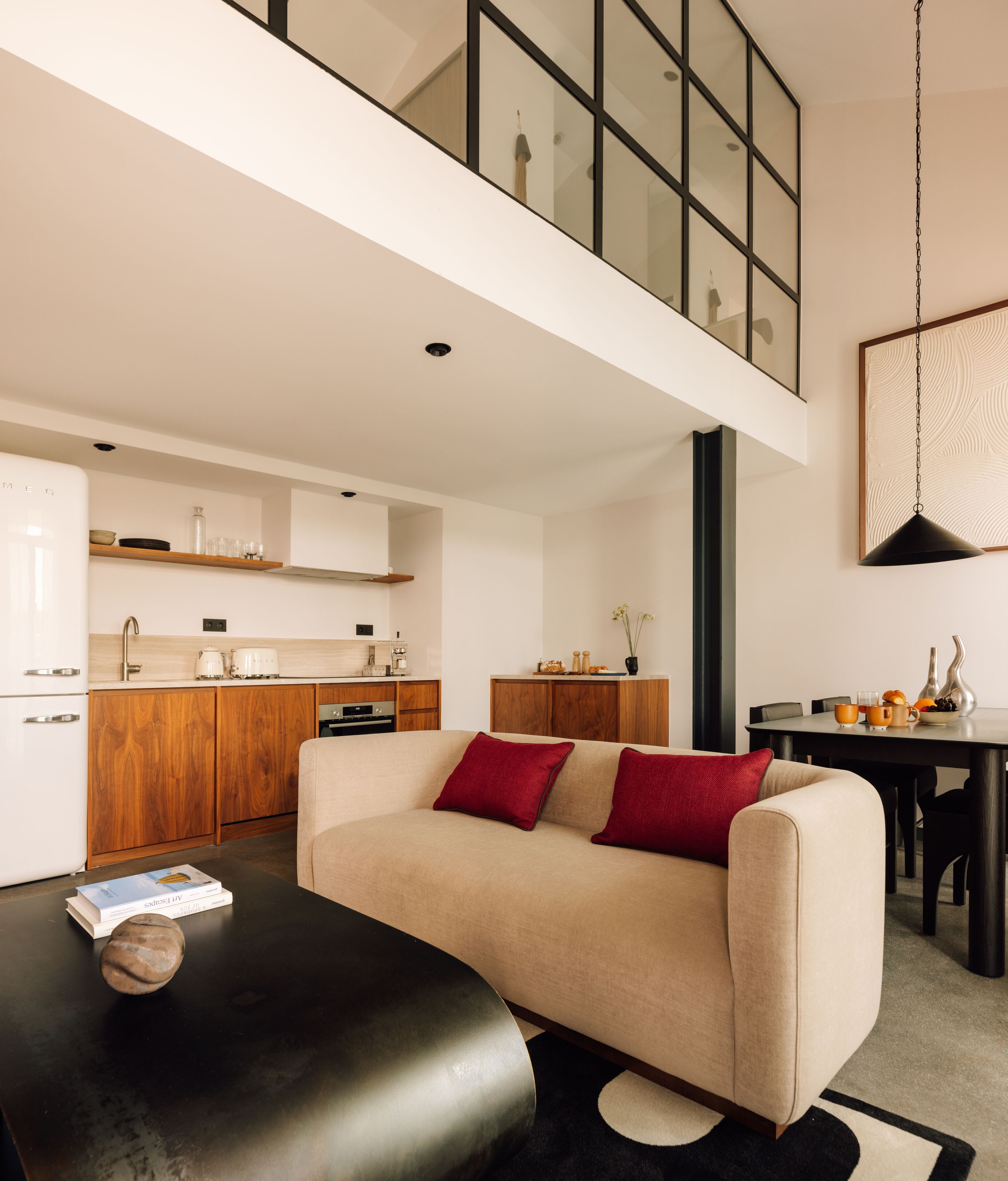 Uma sala de estar moderna com um sofá, uma mesa de centro e uma área de jantar com mesa e cadeiras.