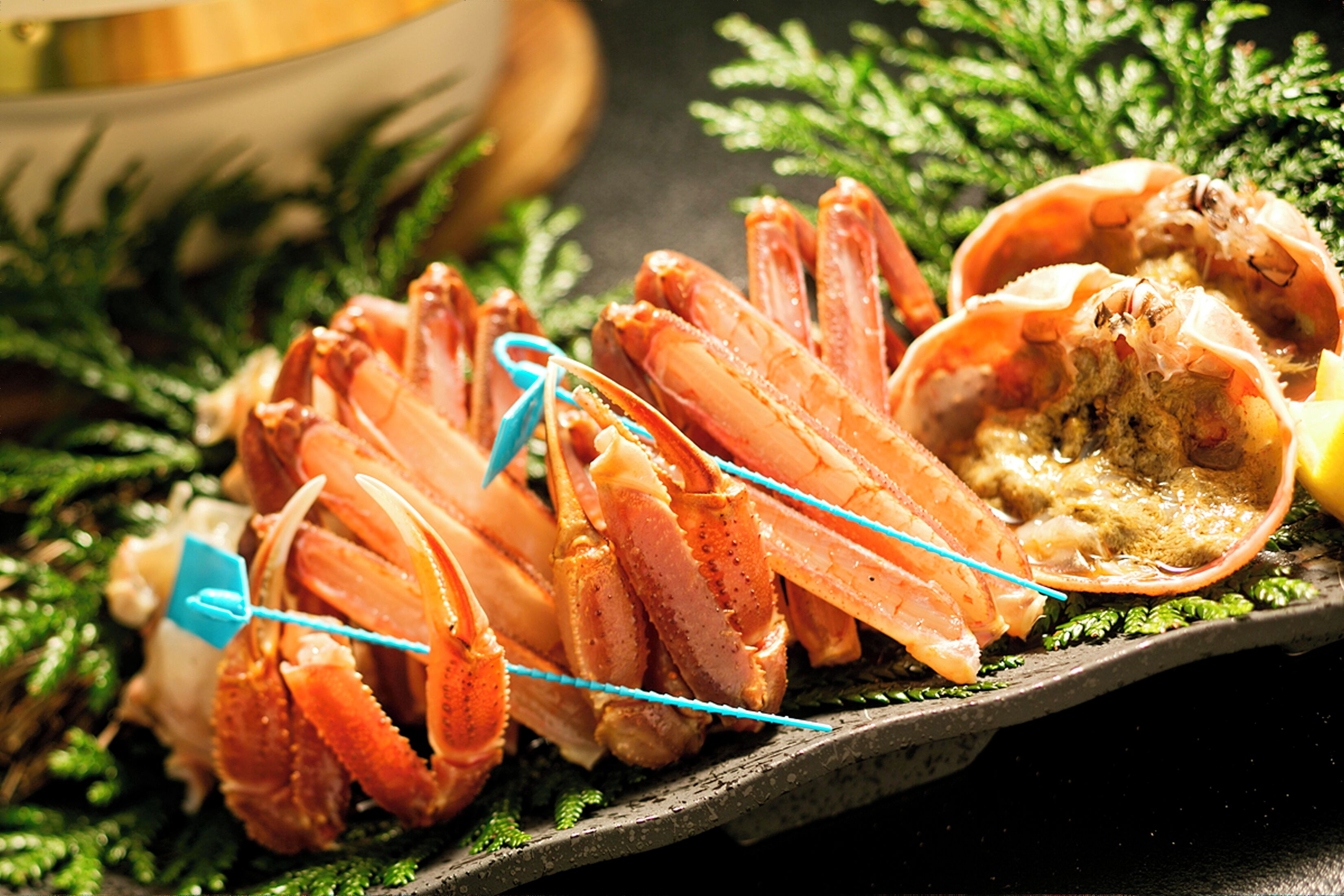 Een schaal vol zeevruchten, met kreeftstaarten en een krab, versierd met groen.