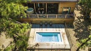 A modern house with a swimming pool, a hot tub, and outdoor seating. - Pool, Pickleball & Basketball Court, Hot Tub, & Playset (Broken Bow)