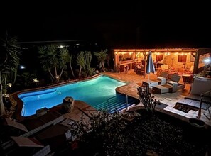 A swimming pool surrounded by outdoor seating and a bar area. - La Casa Palmera - Caminito Del Rey (Cartama)