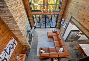 Amplio espacio tipo loft con un sofá modular grande, una chimenea y un comedor con mesa y sillas.